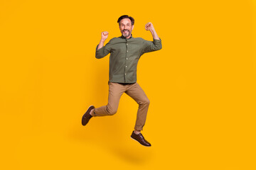 Fototapeta na wymiar Full length body size view of attractive cheerful man jumping celebrating isolated over vivid yellow color background