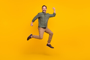 Full length body size view of attractive cheerful lucky man jumping rejoicing isolated over bright yellow color background