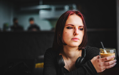 portrait of young teenager redhead girl with cup of hot cappuccino coffee in cafe