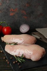 Concept of tasty food with slices of raw chicken fillet on wooden background
