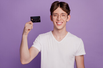 Photo of handsome cheerful man hands hold banking card smile income isolated on violet color background
