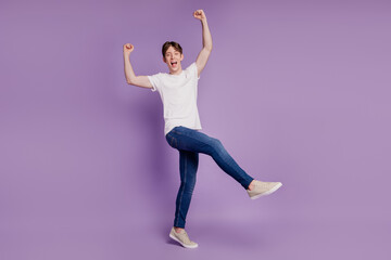 Fototapeta na wymiar Full length photo of young cheerful positive man rejoice victory fists hands isolated on violet color background