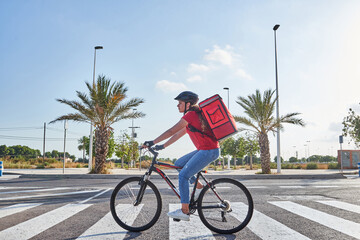 Food delivery woman riding bicycle in city