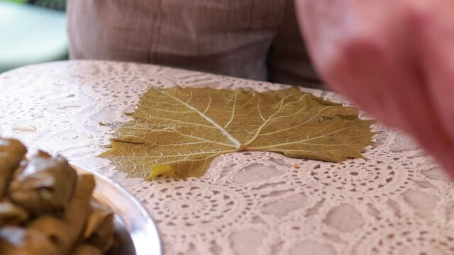 People cook dolma food.
Grape leaves stuffed with minced meat.