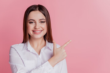 Photo of young girl point finger empty space advertising advise promotion isolated over pink color background