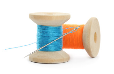 Colorful sewing threads with needle on white background