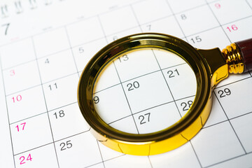 Magnifying glass enlarges the date on the desk calendar. Top view.