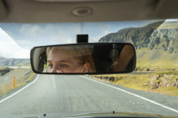 Fototapeta na wymiar Female face looking at the window while traveling by the car through the Iceland