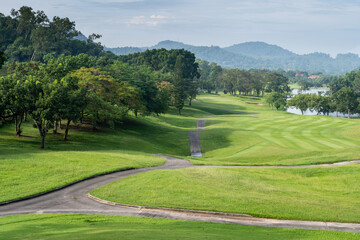 Fototapeta na wymiar The view of the golf course fairway with mountains and ponds is very beautiful