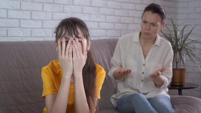 Mother scolds a girl. A stressed mother scolds her little daughter in the room.