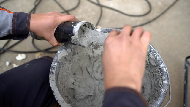 Spray gun for grouting and grouting tiles. Grouting with tiling fugue. Filling the gun with solution. © Ruslan
