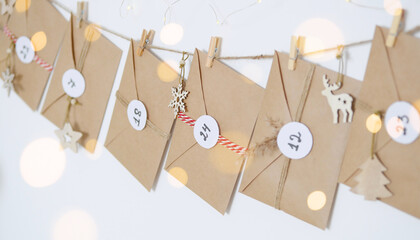 Hand made advent calendar. Preparation to christmas concept. Craft envelopes arranged on a white...