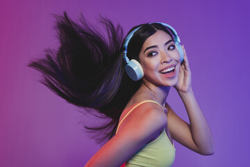 Fototapeta premium Profile photo of funky trendy millennial brunette lady listen music look empty space wear yellow top headphones isolated on neon pink color background