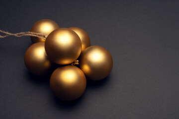 A bunch of gold Christmas balls on a dark background