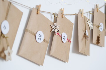 Hand made advent calendar. Preparation to christmas concept. Craft envelopes arranged on a white...