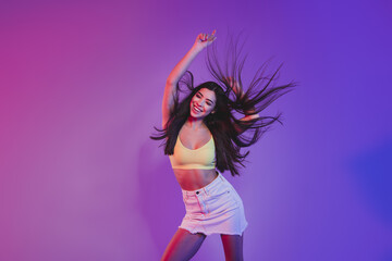 Portrait of attractive cheerful dreamy girl dancing rest relax isolated over vivid violet purple neon color background