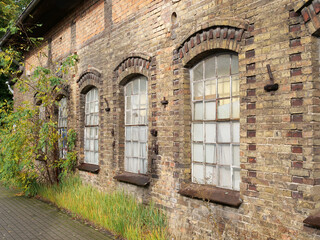 Fototapeta na wymiar Historische Ziegelwand mit Fenstern aus der Jahrhundertwende eines Industriegebäudes