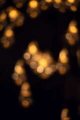 Yellow bokeh lights in the dark. Christmas garland. 