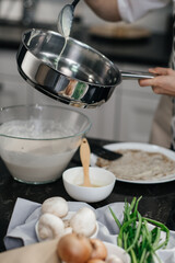 Bright kitchen, professional chef cooks in a frying pan. Cooking pancakes. Vertical view. Hands in the frame.