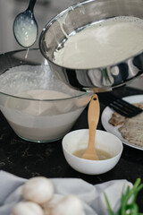 Bright kitchen, professional chef cooks in a frying pan. Cooking pancakes. Vertical view. Hands in the frame.
