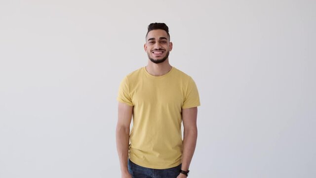 Happy young man smiling and shaking head over white background