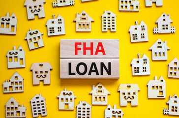 FHA federal housing administration loan symbol. Concept words 'FHA federal housing administration loan' on wooden blocks on a beautiful yellow background. Business and FHA loan concept. Copy space.