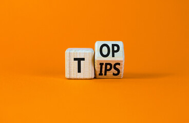 Top tips symbol. Turned a wooden cube with words 'Top tips'. Beautiful orange table, orange...