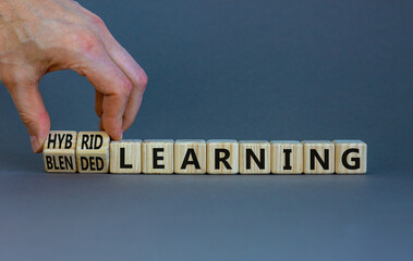 Blended or hybrid learning symbol. Businessman turns cubes, changes words blended learning to...