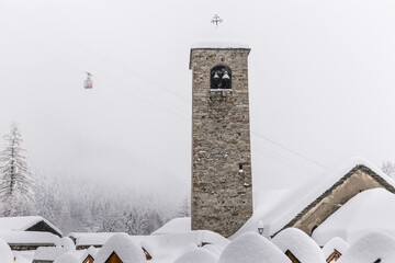 Winter landscape with lots of snow, a bell tower and a cableway. Macugnaga (Staffa – Pecetto)...