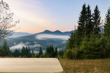 Empty wooden surface and picturesque view of beautiful mountain landscape covered with fog