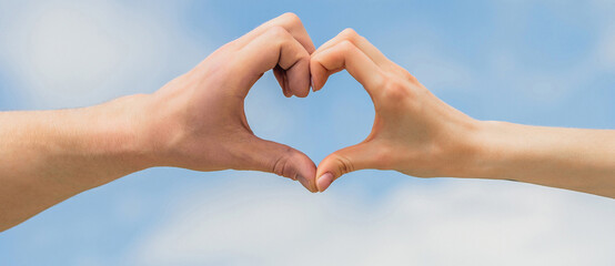 Girl and male hand in heart form love blue sky. Female and man hands in the form of heart against...
