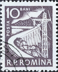 Obraz premium Romania - Circa 1960: a postage stamp printed in the Romania showing a river dam with an electrical high voltage line