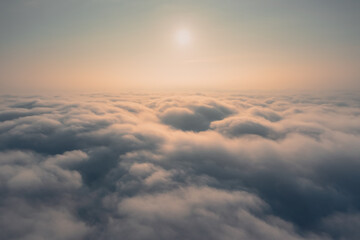 Dawn above the clouds: the sun is above the level of thick clouds. Thick misty clouds cover the ground during dawn.