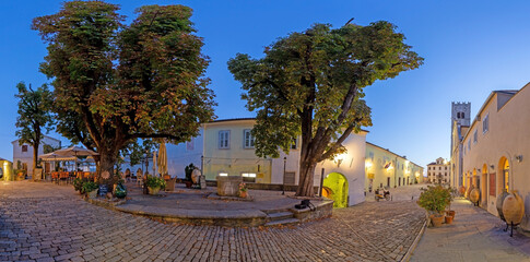 Panorama over the central square of Motovun with St. Stephen's church and city gate at sunrise
