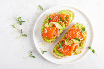 Open sandwiches with salted salmon, guacamole avocado and microgreens. Seafood. Healthy food. Top...