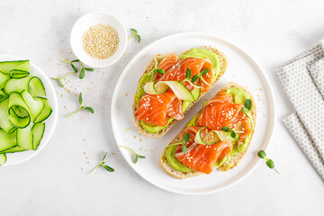 Open sandwiches with salted salmon, guacamole avocado and microgreens. Seafood. Healthy food. Top view.