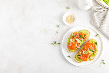 Open sandwiches with salted salmon, guacamole avocado and microgreens. Seafood. Healthy food. Top view.
