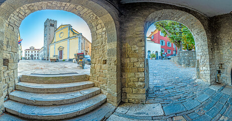 Panorama over the central square of Motovun with St. Stephen's church and city gate at sunrise