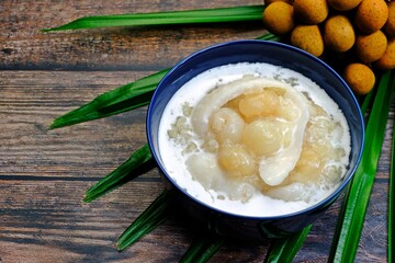 Sweet sticky rice with longan and coconut sliced in coconut milk (Kao niao piak lumyai). Authentic Thai dessert.