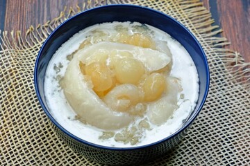 Sweet sticky rice with longan and coconut sliced in coconut milk (Kao niao piak lumyai). Authentic Thai dessert.