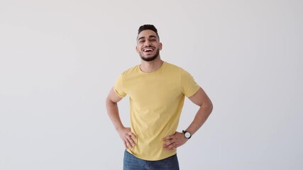 Man with arms akimbo laughing over white background