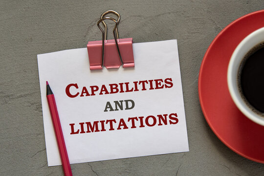 POSSIBILITIES and RESTRICTIONS - words in a white notepad on a gray background with a pencil and a cup of coffee