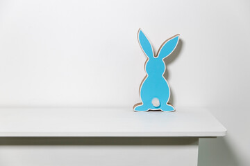 Blue hare on a white chest of drawers. Easter decoration.