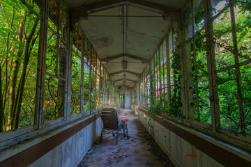 Wheelchair in the hallway of an abandoned sanatorium