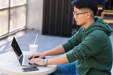 カフェでパソコン作業をする若者