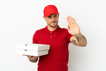 pizza delivery man with work uniform picking up pizza boxes over isolated  white wall making stop...
