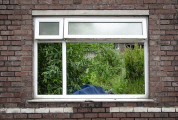 View through the window of the remaining outer wall of the factory