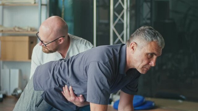 Physiotherapist Conducting a Rehabilitation Session For a Man with a Brain Stroke. Recovery in a Rehabilitation Center, Improving the Quality of Life of a Person with a Disability.