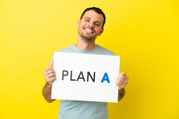 Brazilian man over isolated purple background holding a placard with the message PLAN A