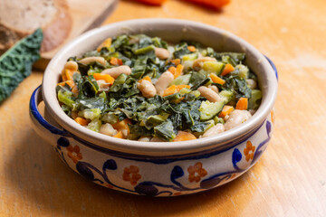 Black cabbage and bean soup on a wooden background Excellent for a healthy and vegan dinner.